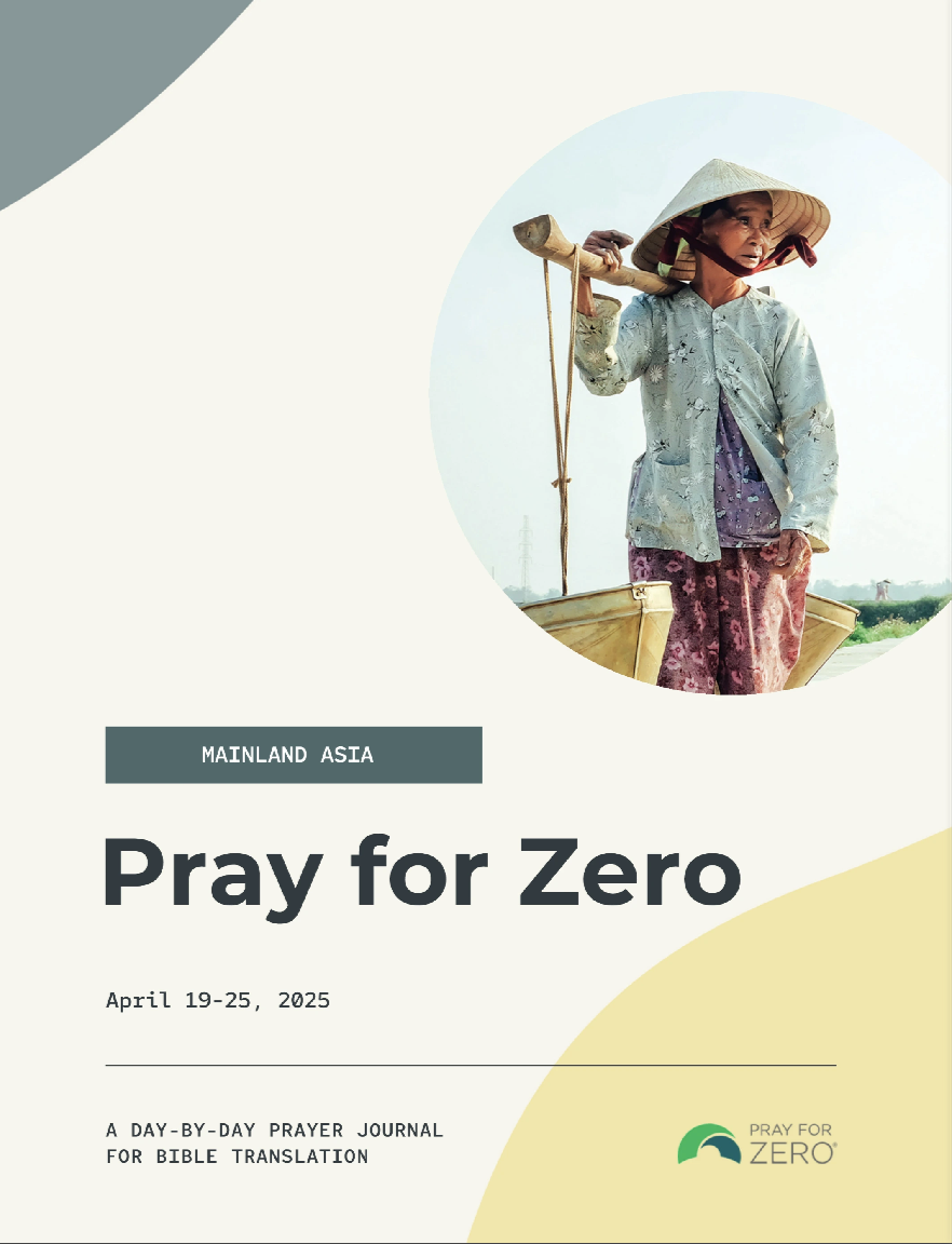 Woman in traditional clothing and conical hat carrying a shoulder pole in rural Mainland Asia, representing those still waiting for Scripture in their language.